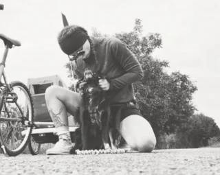 Illustration of the article: With his cart and his cuddly toy, this dog begins a bicycle tour of Europe alongside his mistress and his childhood friend